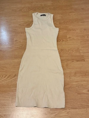Beige ribbad kort klänning - Säljer en beige, ribbad klänning i stretchigt material. Storlek M men passar XS/S. I super bra skick💕