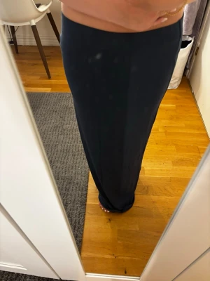 Mörkblå långkjol i stretchigt tyg - Säljer en enkel och stilren mörkblå långkjol med rak passform. Kjolen är gjord i ett mjukt och stretchigt material som sitter bekvämt i midjan. Perfekt att matcha med en crop top eller stickad tröja för en snygg look.💞💞