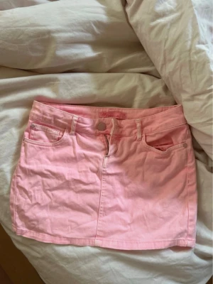 Rosa jeanskjol från Colin's She - Säljer en söt rosa jeanskjol från Colin's She i storlek 36. Kjolen har klassisk femficksmodell, bälteshällor och knappstängning framtill. Perfekt för dig som vill ha en färgglad och enkel kortkjol till sommaren. Säljer pga den var för stor. Gamla ägarens bilder
