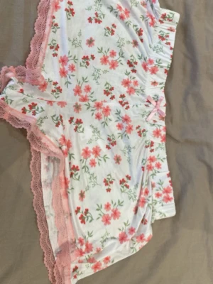 Pjyamasshorts med blommönster  - Små vita shorts med blommor på och har spetskant. Väldigt sköna och är helt oanvända, skriv för mått!❣️