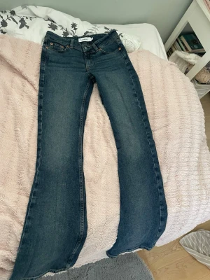 Mörkblå bootcut jeans - Snygga mörkblå bootcut jeans med klassisk femficksdesign och kontrastsömmar. Jeansen har utsvängda ben och är tillverkade i denim med en lätt tvättad look. Perfekta för dig som gillar en retrostil och vill ha ett par jeans som sticker ut. Dom är ganska små i storleken och säljer dom för de är för små i låren.