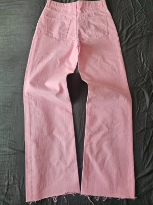 Slutsålda/eftersökta bubbelgumsrosa / klarrosa W27, W28✨ NYA! - FELMÄRKTA FRÅN FABRIK – PASSAR S / 36 🌸Det står strl 42 på lappen, men de saknar stretch och passar strl S/36 (midja 39cm platt). Helt nya/oanvända ljusrosa jeans från Gina Tricots slutsålda Perfect Jeans-kollektion ✨ Hög midja, raka ben med råa benslut (lätta att klippa kortare själv). 100% bomull.📐 Mått platt:• Midja uppe/nere: 39 / 40,5cm• Höjd/Innerben/Längd: 30,5 / 83 / 114cm• Benöppning: 25cm