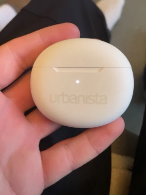 Urbanista vita trådlösa in-ear hörlurar - Snygga vita Urbanista in-ear hörlurar med laddningsetui. Smidig oval form och stilren design i matt plast. Perfekta för musik, poddar och samtal på språng helt nya aldrig använt!!!!!.