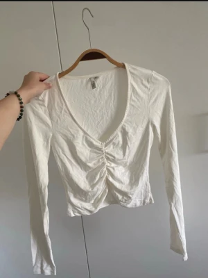 Vit topp från Nelly  - En jättesöt tröja från Nelly i storlek XS. Inga skador eller liknande. Använd 1 gång. Lite skrynklig men inget man tänker på när man har den på sig. Kan även säkert strykas bort☺️ 