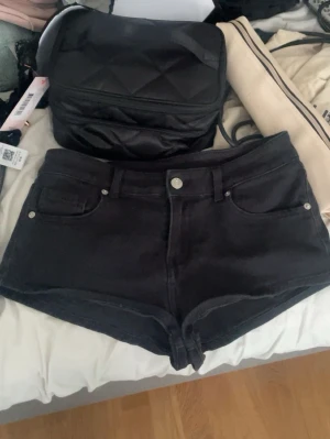 Svarya lågmidjade jeansshorts - Jättefina svarta lågmidjade jeansshorts från H&M. Säljer då de tyvärr inte passar mig längre. Midjemåttet är ca 35-36cm.