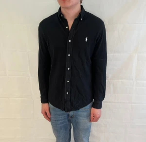 Polo Ralph Lauren Featherweight Mesh Shirt Black - Svart skjorta i 100% bomull, Featherweight Mesh-modell, begagnad i mycket gott skick.