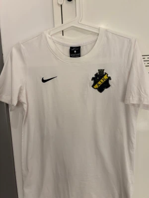 Vit AIK t-shirt från Nike - Säljer en vit t-shirt med AIK:s klubbmärke på bröstet och Nike-logga i svart. Klassisk rund hals och korta ärmar. Passar mig som har S i vanliga fall 🩷