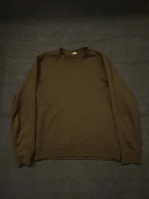 Svart sweatshirt - En enkel och stilren svart sweatshirt med rund halsringning och långa ärmar. Tröjan har ribbade muddar vid ärmslut och nederkant. Perfekt för en avslappnad och clean look. Storlek XS men sitter som S