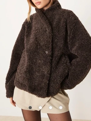 Mörkbrun teddyjacka - Säljer en oversized mörkbrun teddyjacka med knäppning framtill. Jackan har en fluffig, mjuk struktur och två sidofickor. Perfekt för att hålla värmen och ge en trendig look till hösten och vintern. Är i nyskick.