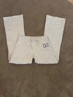 Ljusgrå mjukisbyxor med tryck - Snygga ljusgrå mjukisbyxor med raka ben och resår i midjan, ifrån Gina tricot 14+ i storlek s. Säljer på grund av att dem är lite för korta för mig (jag är 170cm)💕 andvända ca två gånger💕