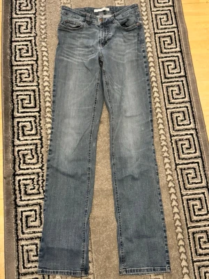 Blå raka jeans från MAC - Ett par klassiska blå jeans med raka ben. Jeansen har fem fickor och normal midja. Materialet är denim i bomull och färgen är ljusblå med tvättade partier för en avslappnad look. De sitter som M/S, men lite mer som S. 