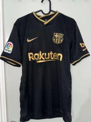 FC Barcelona 20/21 Borta tröja - Säljer min borta barca tröja från säsong 20/21. Tröjan har tyvärr ett hål som har sytts ihop, annars är tröjan i bra skick.