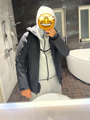 Svart vindjacka med huva från Haglöfs ”äkta” Oanvänd  - Snygg svart vindjacka från Haglöfs med huva och dragkedja framtill. Jackan har minimalistisk design, diskret logga på bröstet och praktiska fickor. Perfekt för blåsiga dagar och funkar till streetwear-stil. Ny pris 2999kr 
