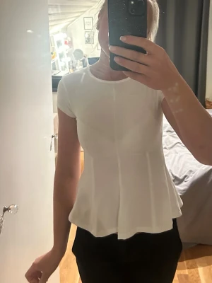 Vit peplumtop med kort ärm - Blus från Gina tricot i strl Xs med prislapp kvar. Lite genomskinlig, nypris 279