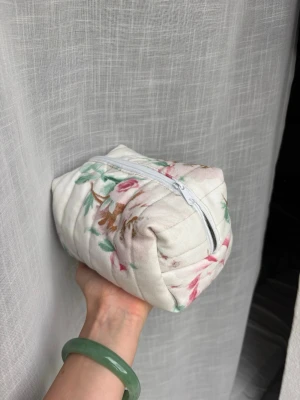 Blommig quiltad necessär i tyg - Söt quiltad necessär i vitt tyg med blommigt mönster i rosa, grönt och brunt. Sydd av mig! 💕🩷🌸