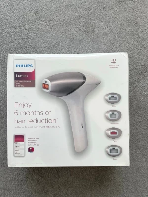 Philips Lumea IPL hårborttagningsapparat - Philips Lumea IPL hårborttagningsapparat för långvarig hårreducering. Kommer med fyra smarta munstycken för bikinilinje, armhålor, ansikte och kropp. Vit och silverfärgad design, sladdlös och sladdansluten användning. Passar flera hudtoner och hårfärger.