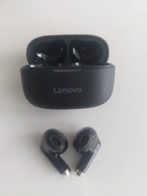 Svarta trådlösa in-ear från Lenovo - Snygga svarta trådlösa in-ear hörlurar från Lenovo med laddningsetui. Hörlurarna har en stilren och modern design med blanka detaljer och kompakt form. Perfekta för musik, poddar och samtal på språng.