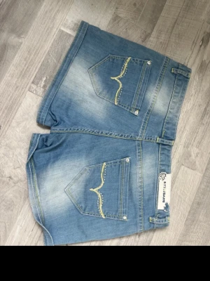 Snygga shorts med gröna detaljer  - Säker ett par snygga lågmidjade shorts med gröna detaljer både fram och bak från Vogue style! Går att göra om till en jeanskjol.