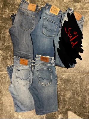 4 par blå jeans från Replay & Jack & Jones - Säljer ett paket med 4 par blå jeans i olika tvättar från Replay och Jack & Jones. Klassisk femficksmodell med raka ben och skinnpatch bak i midjan. Jeansen är i olika nyanser av blått, från ljus till mörk denim. Perfekta för dig som vill ha flera stilar att variera mellan.