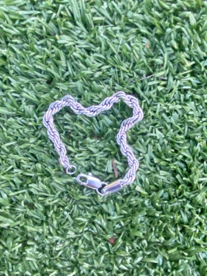 Tjockt silverfärgat kedjearmband - Säljer ett stilrent armband i silverfärg med tvinnad kedjedesign. Armbandet har en robust karbinhake som lås och passar perfekt för dig som gillar en chunky look. Materialet ser ut som metall och armbandet har en modern, trendig känsla.