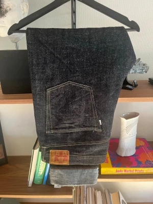 Omoto Denim - 0411 15.5oz Slub-Nep Denim Straight Fit - Säljer ett par nästan oanvända jeans från Omoto Denim i Slub Nep Selvage Denim. Jeansen är inköpta på Göteborg Manufaktur och mera information finns på deras hemsida. Har använt dom max 3 gånger. Inga fades och aldrig tvättat dom. Luras inte av att de är i storlek 40 utan gå på måtten. Japanska storlekar är väldigt små. Jeansen är upplagda och inseam är numera 80cm. Har ni fler frågor eller funderingar så skicka bara meddelande.  