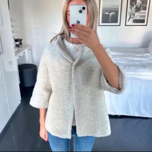 Ljusgrå ullkappa med trekvartsärm - Stilren ljusgrå kappa i mjuk ullmix med trekvartsärmar och enkel knäppning framtill. Rak passform och minimalistisk design som passar perfekt till jeans eller klänning. Snygg krage och diskreta sömmar för en clean look. Storlek s lite oversized💓💓