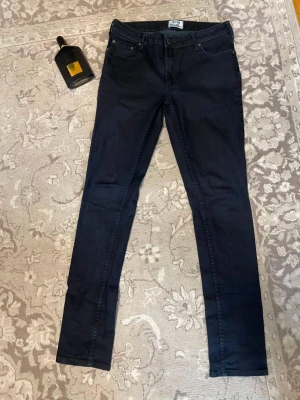 Svarta skinny jeans från Acne Studios - Säljer ett par svarta skinny jeans från Acne Studios. Jeansen har klassisk femficksdesign, smal passform och är tillverkade i ett stretchigt bomullsmaterial för extra komfort. Perfekta för en stilren och modern look.