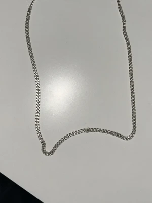 Silver kedjehalsband - Snyggt halsband i silver med klassisk kedjedesign. Halsbandet har en enkel och stilren look som passar till många olika outfits. Säljer då jag inte använder det längre, finns stämpel. 