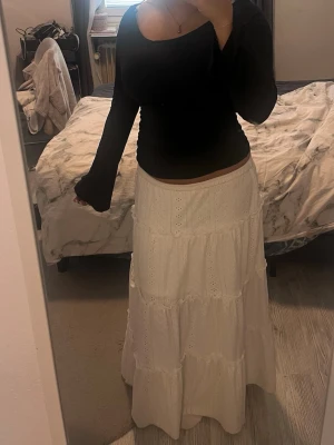 Vit långkjol - Säljer en superfin vit långkjol med små volanger och broderade detaljer. Den har elastisk midja. Jag är ca 164cm