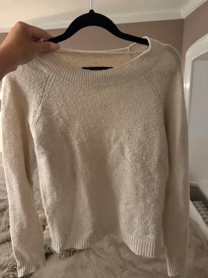 Beige stickad tröja - Mysig beige stickad tröja med rund halsringning och långa ärmar. Tröjan har en enkel, klassisk design med ribbstickade muddar vid ärmslut och nederkant. Perfekt för lager på lager och passar till det mesta i garderoben.
