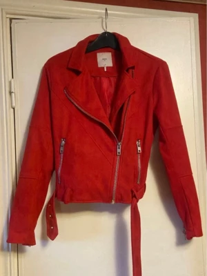 Röd mjuk jacka med bälte - Snygg röd mjuk jacka med asymmetrisk dragkedja, två framfickor med dragkedjor och bälte i midja,Perfekt för dig som vill sticka ut med en färgstark look.