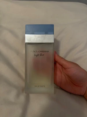 Dolce & Gabbana Light Blue parfym - Fräsch parfym från Dolce & Gabbana, Light Blue. Flaskan är rektangulär i frostat glas med en stilren blå plastkork och silverfärgad detalj. Eau de toilette som ger en lätt och upplyftande doft, perfekt för dig som gillar fräscha toner.