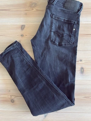Replay Jeans - Säljer ett par svarta slim fit jeans från Replay. Jeansen har klassisk femficksdesign, svarta sömmar och en snygg tvättad look. Passformen är smal och materialet är mjukt och stretchigt för extra komfort. Mycket fint skick och är i storlek 30/34. Hör av er vid funderingar