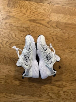 New bailunsy - Säljer ett par fräscha vita sneakers från New Bailunsy med mesh och syntetpaneler. Skorna har snörning, rund tå och en chunky sula. Perfekta för dig som gillar sportig och clean stil.