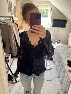 Mörkblå spetsblus från Anna Field - Säljer en mörkblå, långärmad spetsblus från Anna Field. Blusen har v-ringning och är helt täckt av vacker spets med transparenta partier. Perfekt att styla med jeans eller kjol för en trendig look.