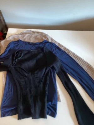 Svart ribbad långärmad topp - Säljer en svart ribbad långärmad topp med figurnära passform. Toppen har en snygg struktur med markerade sömmar och är perfekt för dig som gillar en stilren men edgy look.