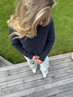 Mörkblå stickad arket tröja - Mysig mörkblå stickad tröja med långa ärmar. Tröjan har en enkel, klassisk design med ribbstickade muddar vid ärmslut och nederkant. Perfekt för kyligare dagar och lätt att matcha med olika outfits. Ifrån Arket i helt nyskick!!