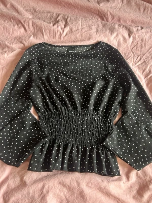 Svart vit topp  - Svart vit prickig topp med utsvängda armar och tight midja. Original pris (499) är i storlek m men passar även för storlek S