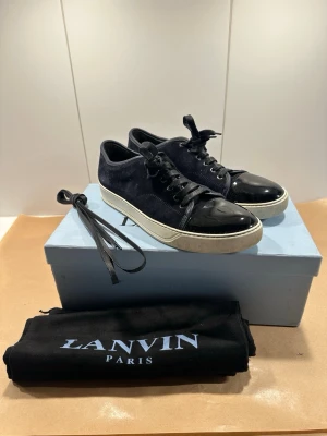 Lanvin skor - Sjukt snygga lanvin skor till salu är, perfekta för sommaren! Skorna är storlek 9 vilket tyder på storlek 43! Grymt skick, ser exakt ut som bilderna så avgör själv! Färgen är navy blue och allt medföljer! Skriv gärna vid fler frågor🙏