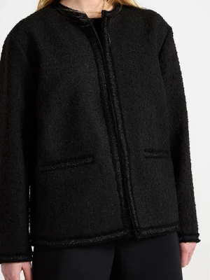Svart bouclé cardiganjacka från Lindex - Stilren svart cardiganjacka från Lindex i bouclématerial. Jackan har rund halsringning, raka ärmar och två fickor framtill. Enkel design utan knappar eller dragkedja, perfekt för en clean och modern look.