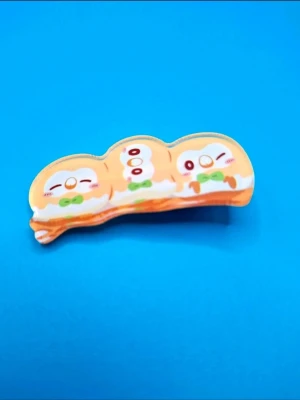 Pokemon-hårklämma - En hårklämma i metall och plast med motiv av tre Rowlet. Ca 6cm lång.