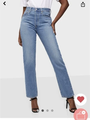 Blå raka jeans från Levi's 501 - Klassiska blå jeans från Levi's i rak modell med fem fickor och hög midja. Jeansen har en mellanblå tvätt och är tillverkade i slitstark denim med den ikoniska läderpatchen bak i midjan. Perfekta för en tidlös stil. Knäpps med knappar. Crop Athens