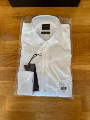 Oscar Jacobson Skjorta - Säljer denna stilrena och klassiska Non Iron Twill Oscar Jacobson Skjorta då jag aldrig fick användning för den. Skjortan är fortfarande i plasten den kommer i från affären, och påse, kvittot och prislapp finns kvar. Storleken och modellen är 38/15 slim, passar mig bra som har M i alla kläder! Priset är inte fast, kontakta för fler bilder, info eller förhandling👍