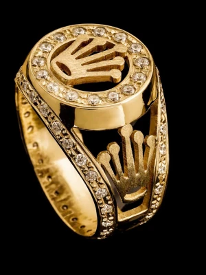 Guldfärgad ring med stenar och krona - Säljer en riktigt snygg guldfärgad ring med bling runt hela ringen och en stor krona på ovansidan. Ringen har även mindre kronor på sidorna och är dekorerad med gnistrande stenar som ger en lyxig känsla. Perfekt för dig som vill sticka ut och visa stil.  Guldpläterad mässing. Stl: 9,5.   Diameter 19,6m, omkrets invändigt 60,2mm