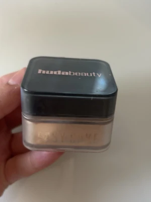 Huda Beauty Easy Bake löspuder - Säljer ett Huda Beauty Easy Bake löspuder i färgen banana bread som är knappt använd. Pudret har en ljus beige ton och ger en matt finish. Perfekt för att fixera sminket och få en jämn look. Smidig att ta med i väskan. 