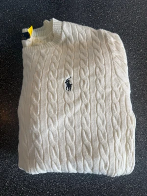 Vit kabelstickad tröja - Riktigt fin o bra tröja som aldrig blivit använd, sitter som en. Xs eller mindre small i storleken, färgen är lite off white