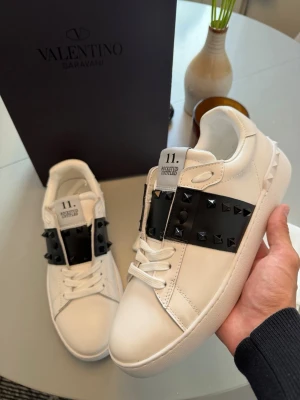 Valentino vita sneakers med nitar - Säljer nu dessa Valentino Opens i storlek 43. Riktigt snygga skor och perfekta nu inför hösten och skolstarten. Skorna är självklart äkta, kan visa bild på kvitto i DM✅😊 Skriv till mig vid minsta lilla frågor eller funderingar🤝