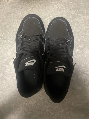 Svarta Nike sneakers, air Jordan Travis skott - Snygga svarta Nike sneakers med vita kontrastsömmar och klassisk logga på plösen. Storlek 42.