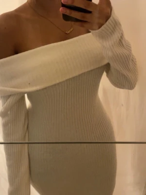 Vit ribbad offshoulder klänning - Superfin vit ribbad klänning med offshoulder-design, lång ärm och  stickad 