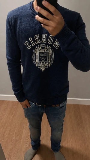 Morris mörkblå tröja med tryck - Snygg Mörkblå stickad tröja från Morris  logotyp och text på bröstet⭐️⭐️⭐️. Perfekt för kallare tider, modellen på bild är 181cm 73kg😎